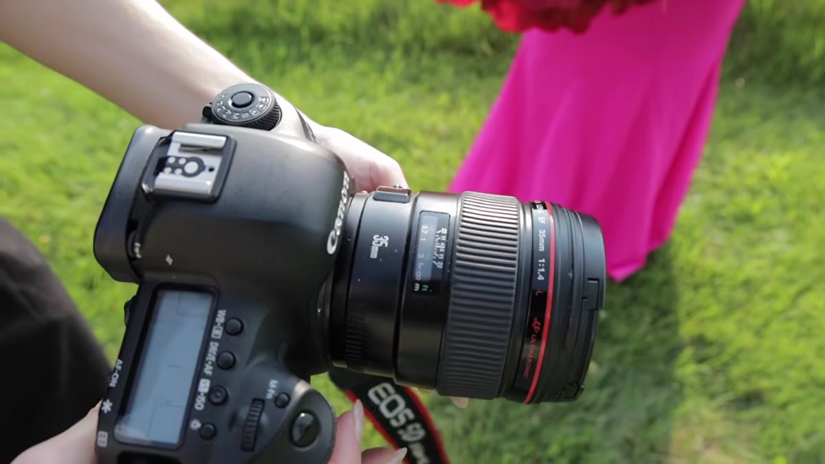 Jessica switching lenses, holding 35mm prime up to camera