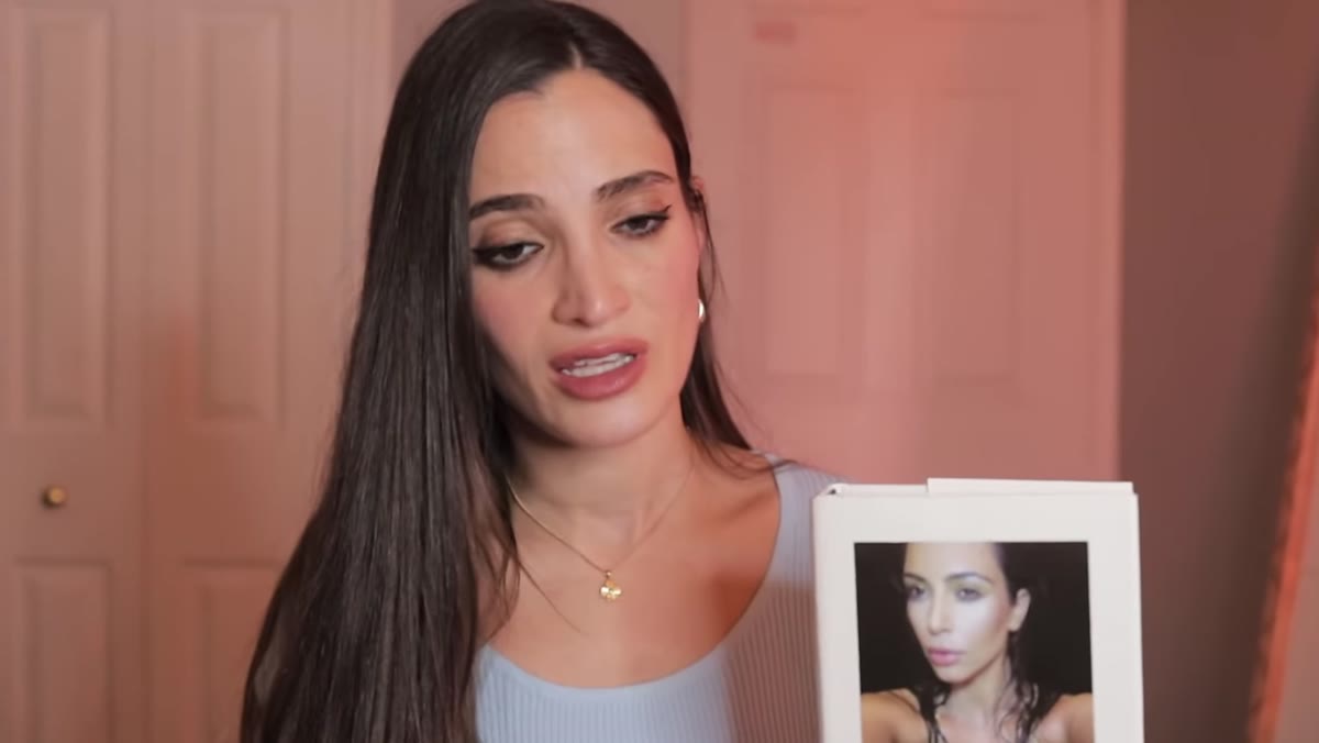 Jessica holds up the book showing its cover and price