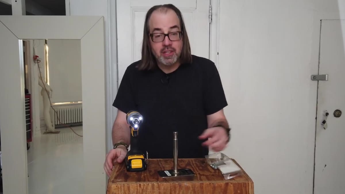 Screw gun driving screws through baby plate holes into a wooden surface