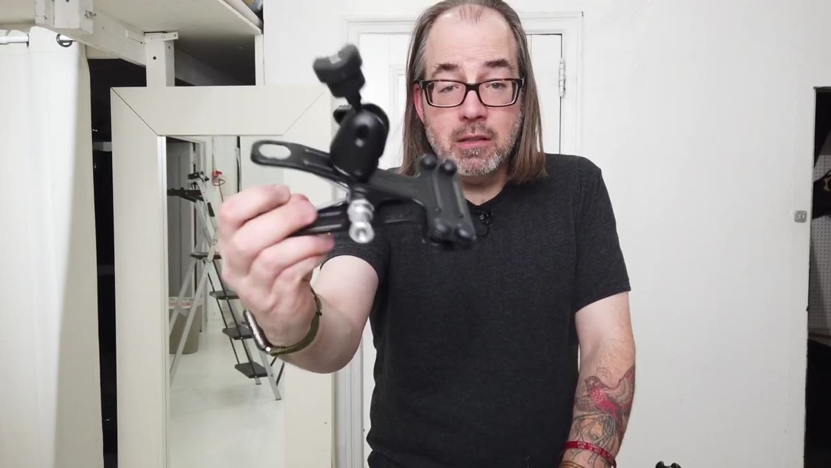 Justin clamp held up showing clamp, ball head, and shoe