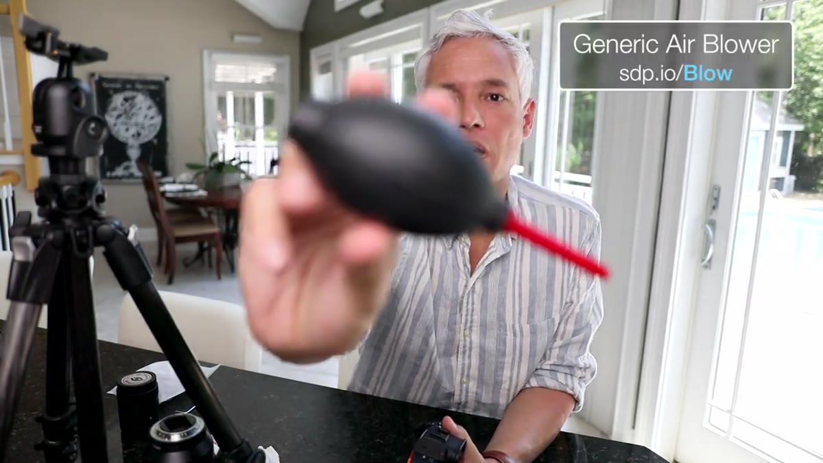 Using a bulb blower inside the camera body to clear dust