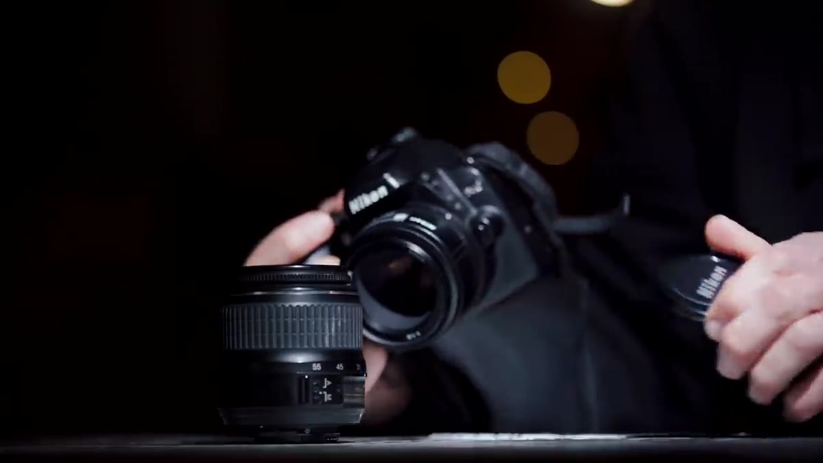 Close-up of the 50mm f/1.8 lens being held up to camera