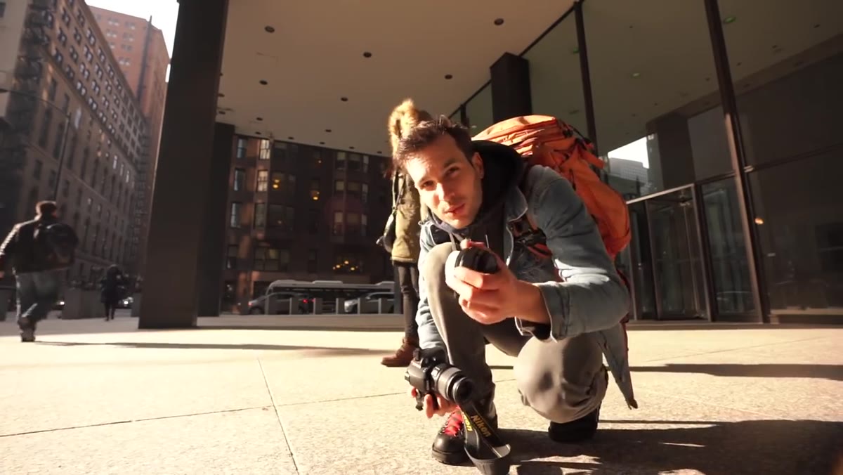 Photographer preparing to shoot portrait subject outdoors with kit lens