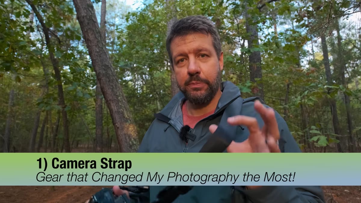 Mark handholding the camera with a strap, moving freely between trees