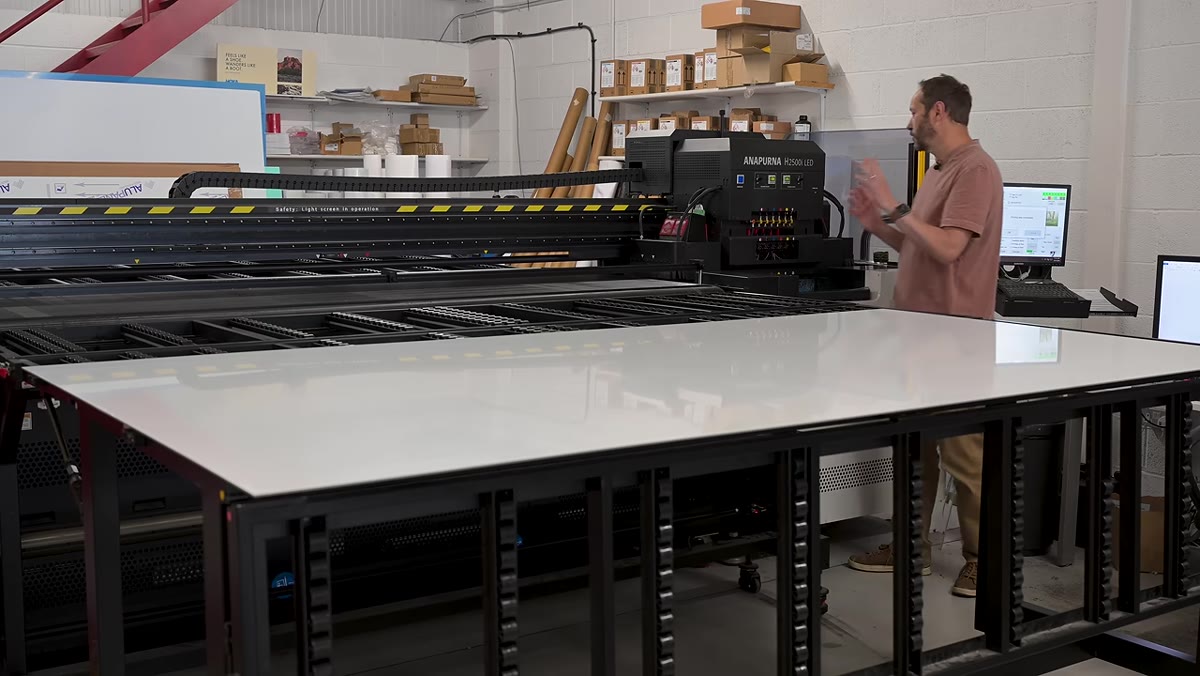 UV inkjet printer in operation with visible UV curing light illuminating the panel