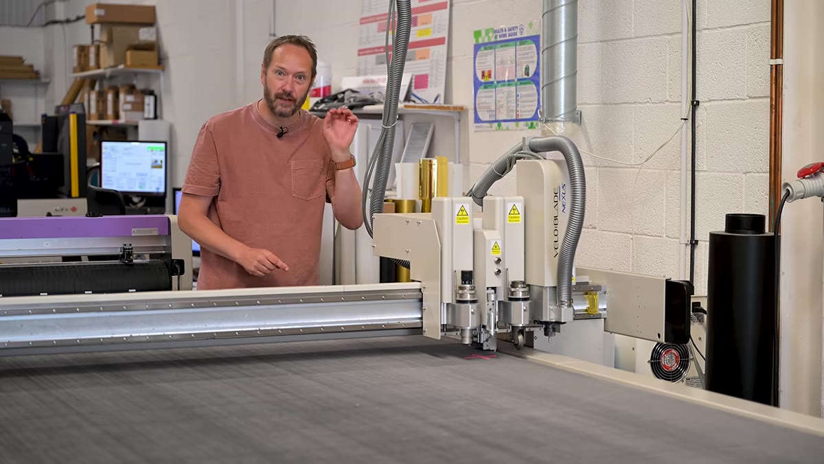 CNC router machine cutting printed aluminum panel into individual prints