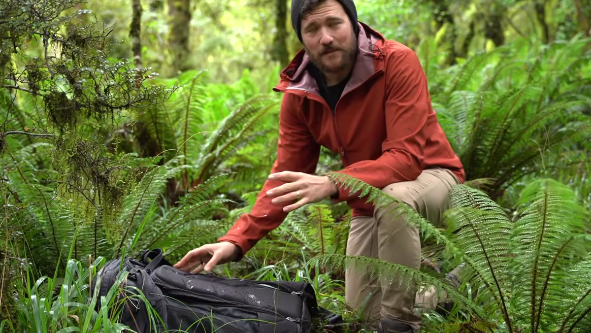 Patino standing in landscape, scanning environment before shooting