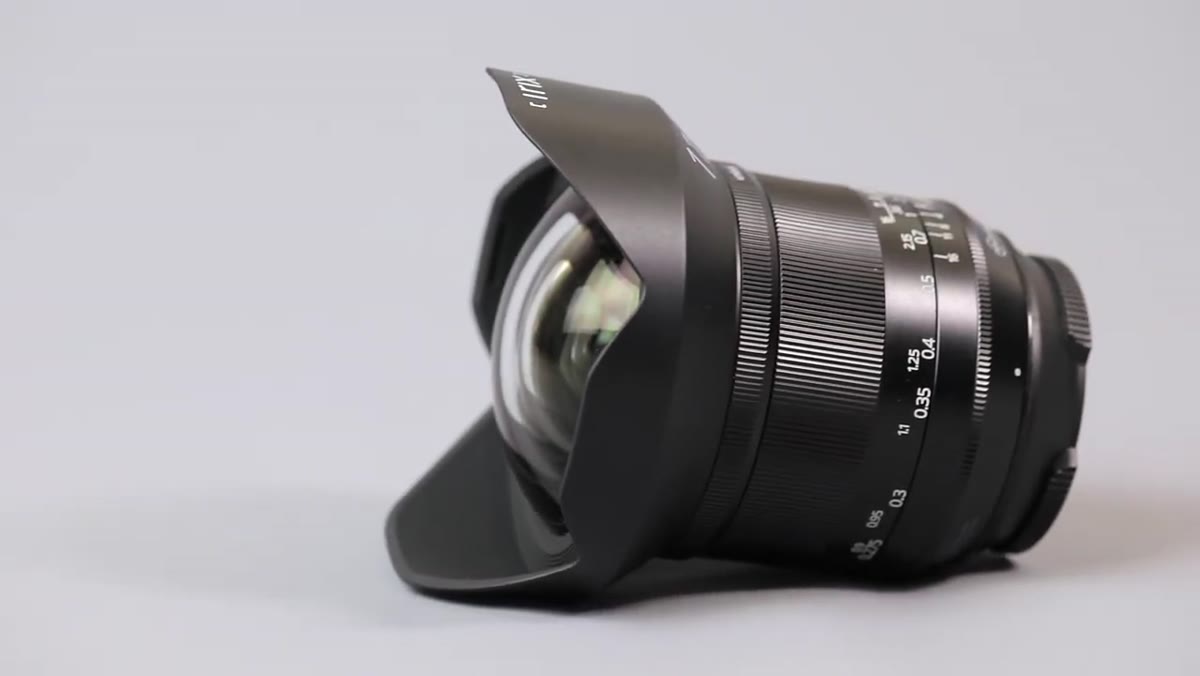 Reviewer showing the permanently attached lens hood and metal focus ring
