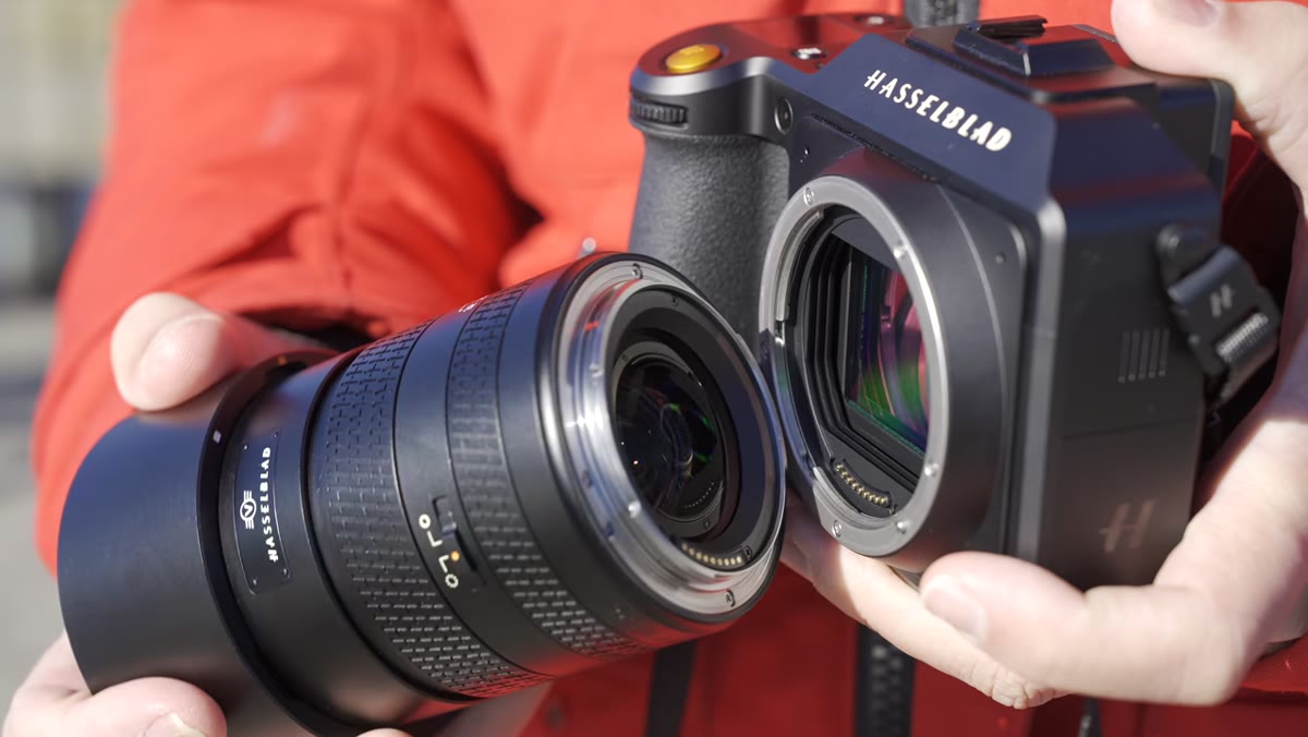 Tony holding the 90V lens next to a full-frame 85mm f/1.4 for size comparison