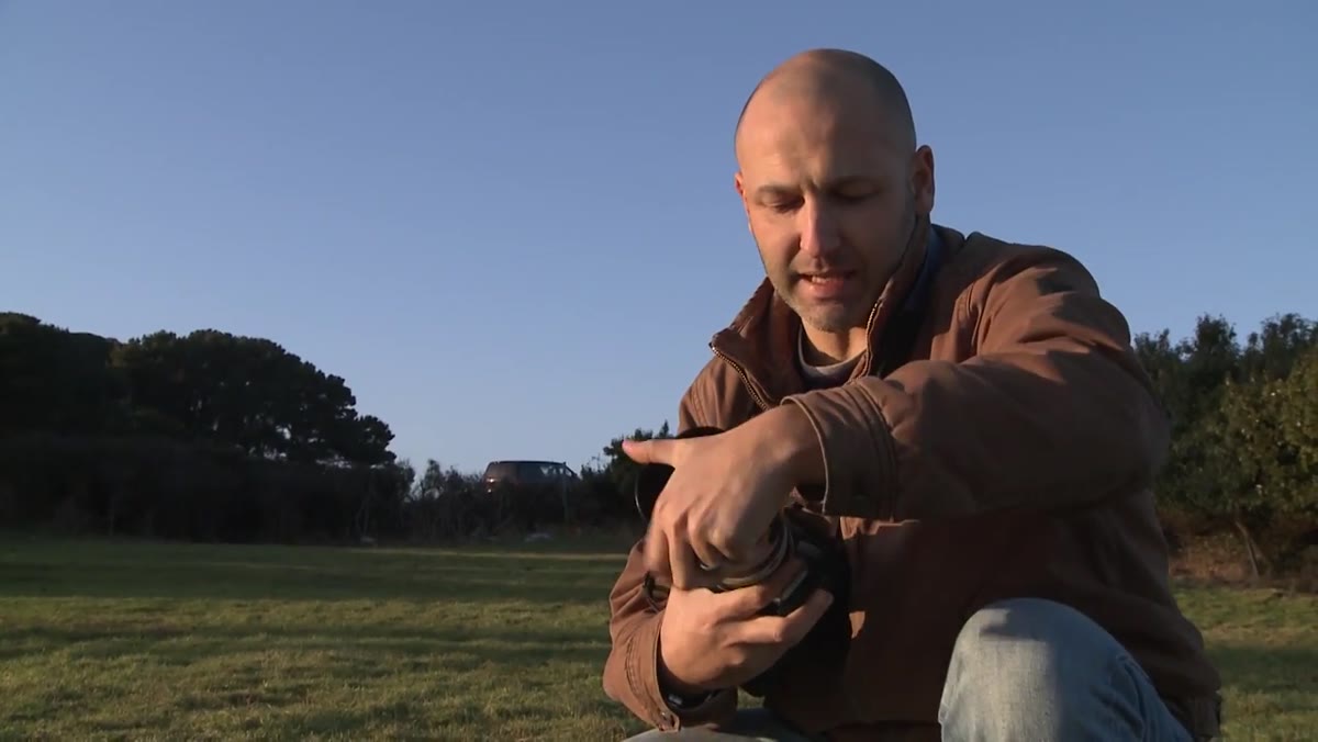 Lens hood being placed onto front of lens