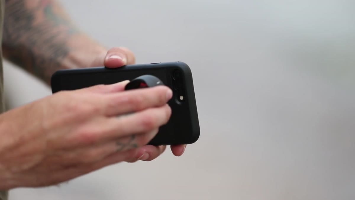 Moment lens being twisted onto phone case mount, alignment lines visible