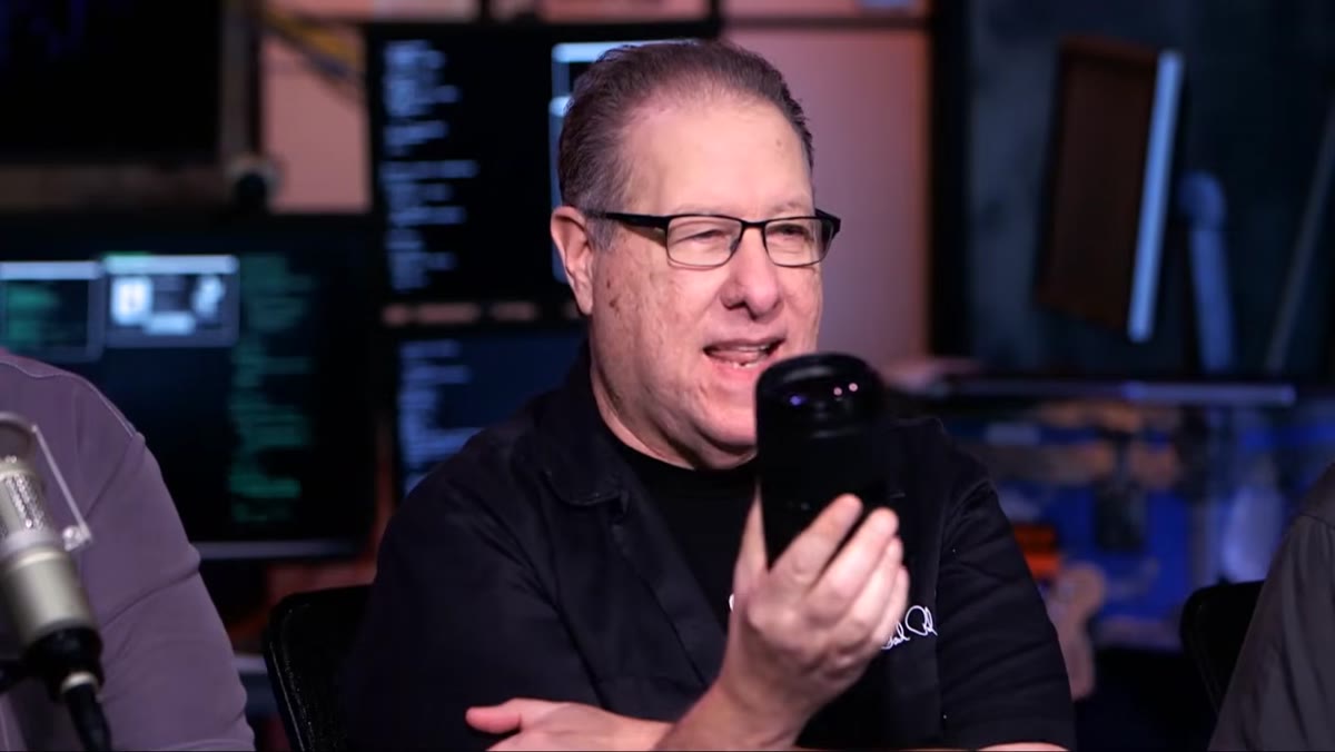 Scott Kelby holding Canon 24-240mm lens on desk