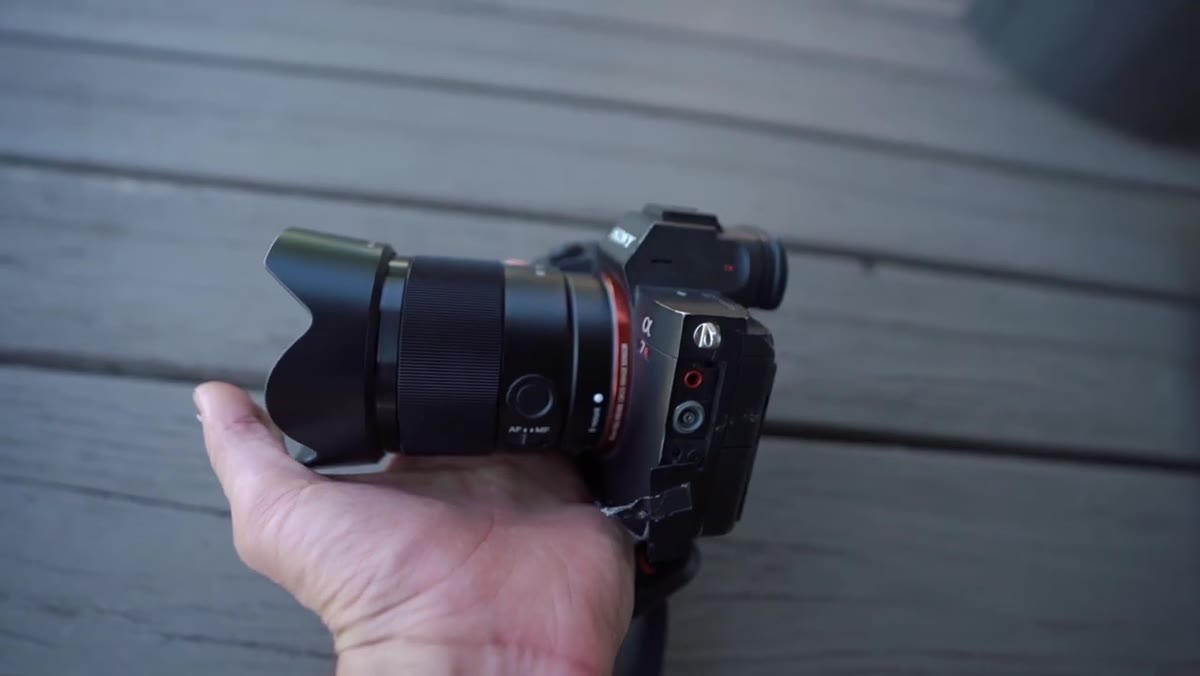 Lambert demonstrating custom function button on lens barrel