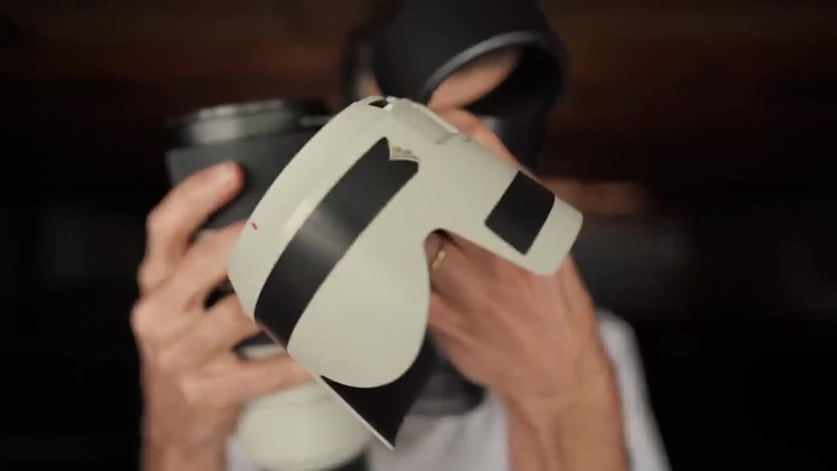 Lens hood held up toward camera, clearly visible on screen
