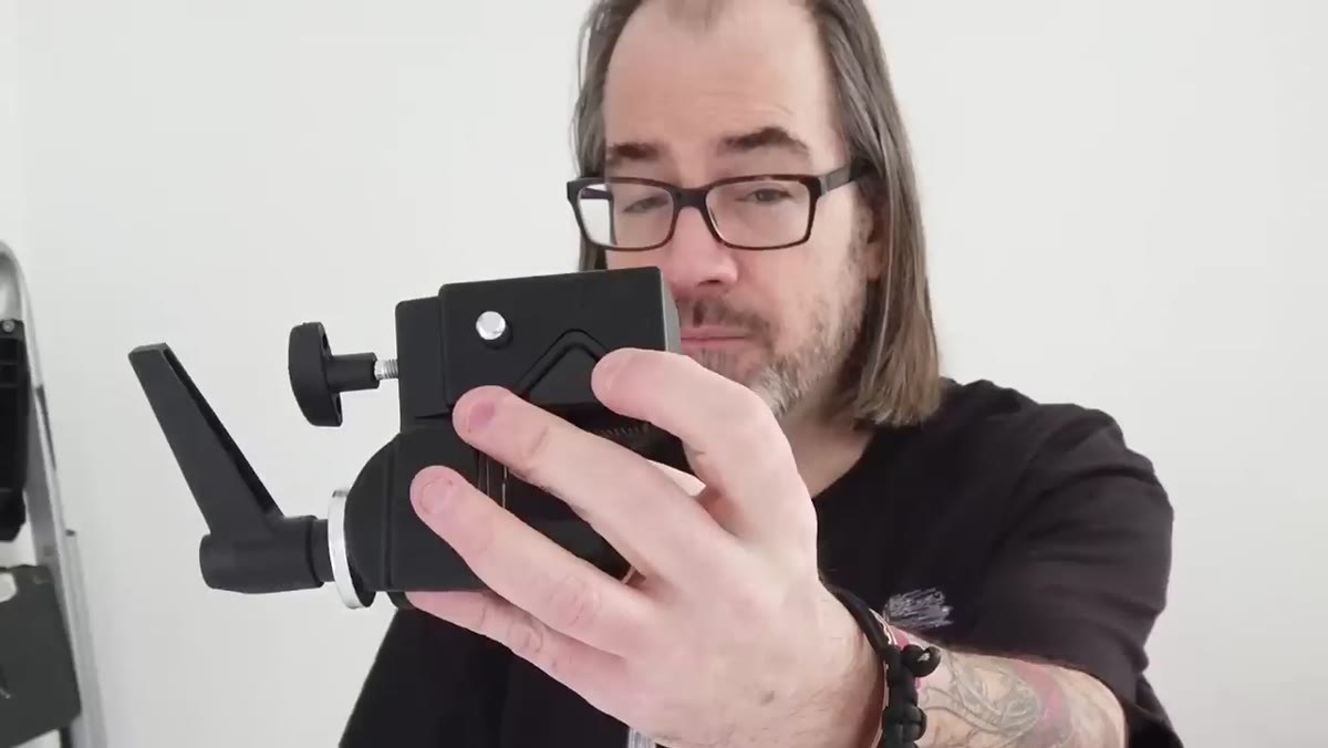Finger pressing small button on clamp while pin is being inserted