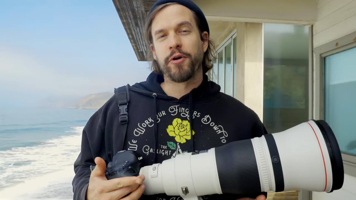 Photographer scanning coastline with 600mm mounted on tripod